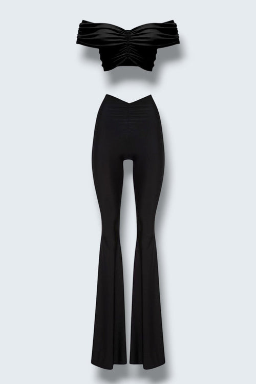 The Saint 54 black two-piece set with off-shoulder draped crop top and high-waisted wide-leg trousers.