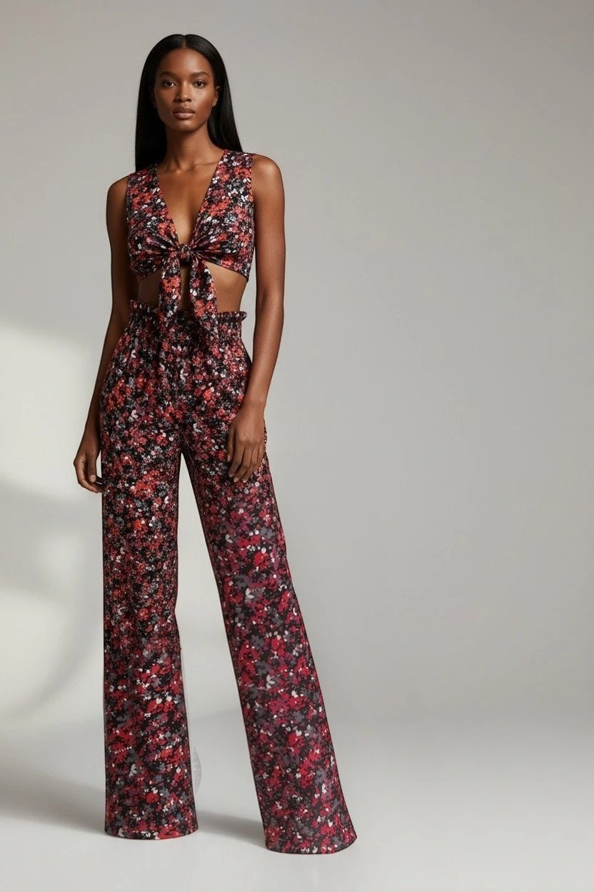 Model wearing The Saint 54 Give&Shine set featuring a floral print tie-front vest and high-waisted wide-leg trousers.