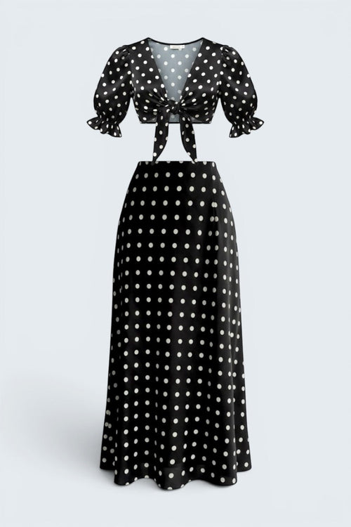 The Saint 54 black and white polka dot two-piece set with a tie-front puff sleeve top and bias-cut midi skirt.