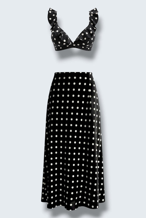 The Saint 54 black and white polka dot two-piece set featuring a ruffled bralette top and a bias-cut midi skirt.