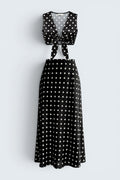 The Saint 54 black and white polka dot two-piece set featuring a tie-front crop vest top and a bias-cut midi skirt.