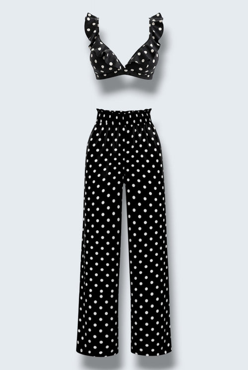 The Saint 54 black and white polka dot two-piece set featuring a ruffled crop top and high-waisted wide-leg trousers.