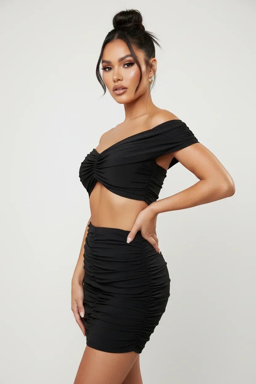 The Saint 54 black ruched off-the-shoulder crop top and mini skirt set. Model is 169cm wearing XS/S.